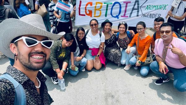 The Safer-I team including others posing for a picture before a pride banner.